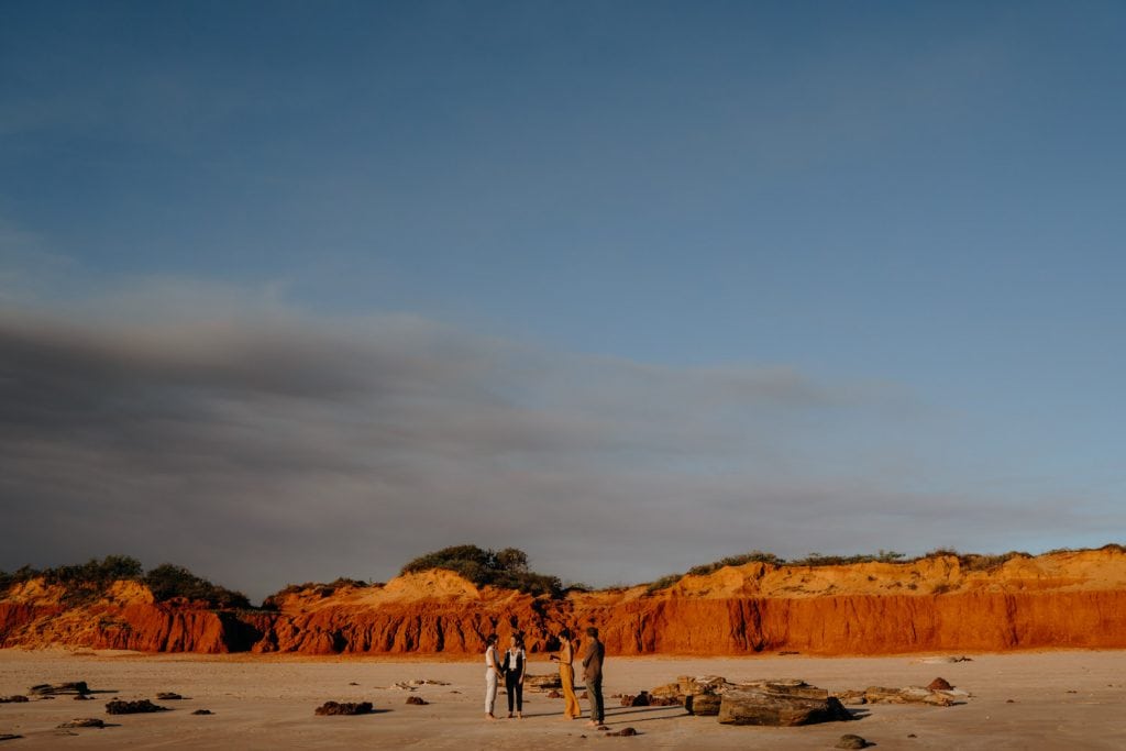 intimate Broome elopement wedding on beach with red cliffs as backdrop 