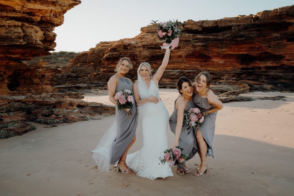 bride and her three bridesmaids having fun on the beach at relaxed Broome wedding