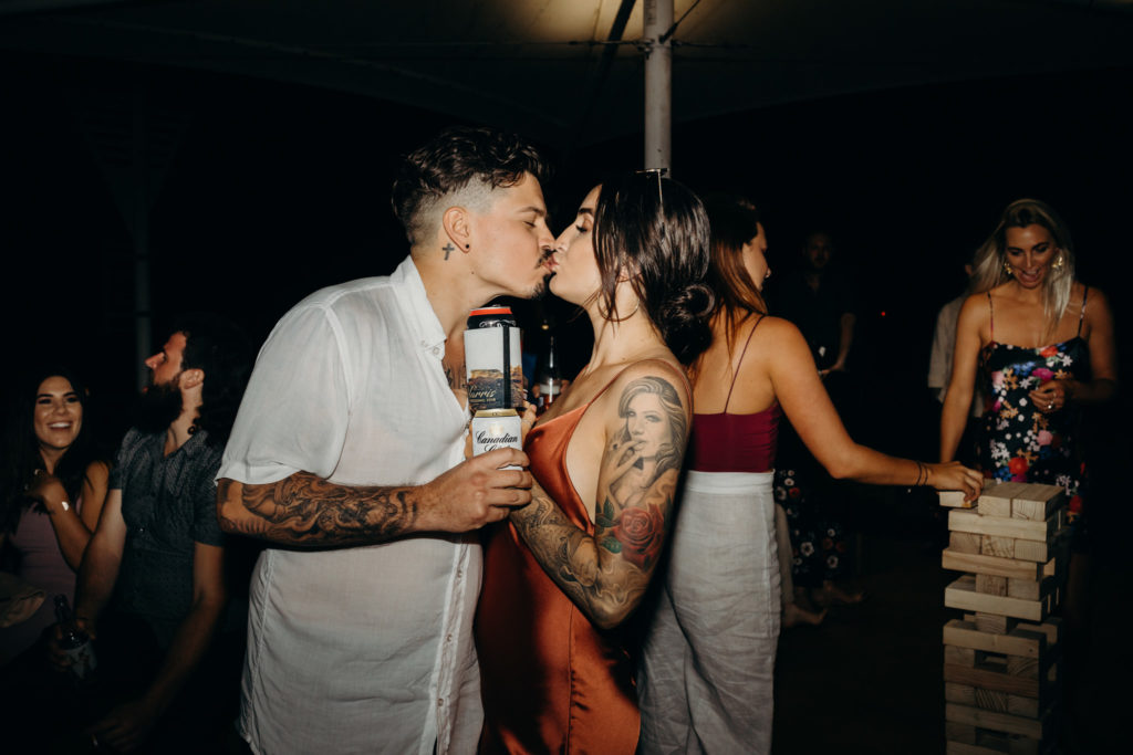 man and woman with tattoos kissing on dance floor