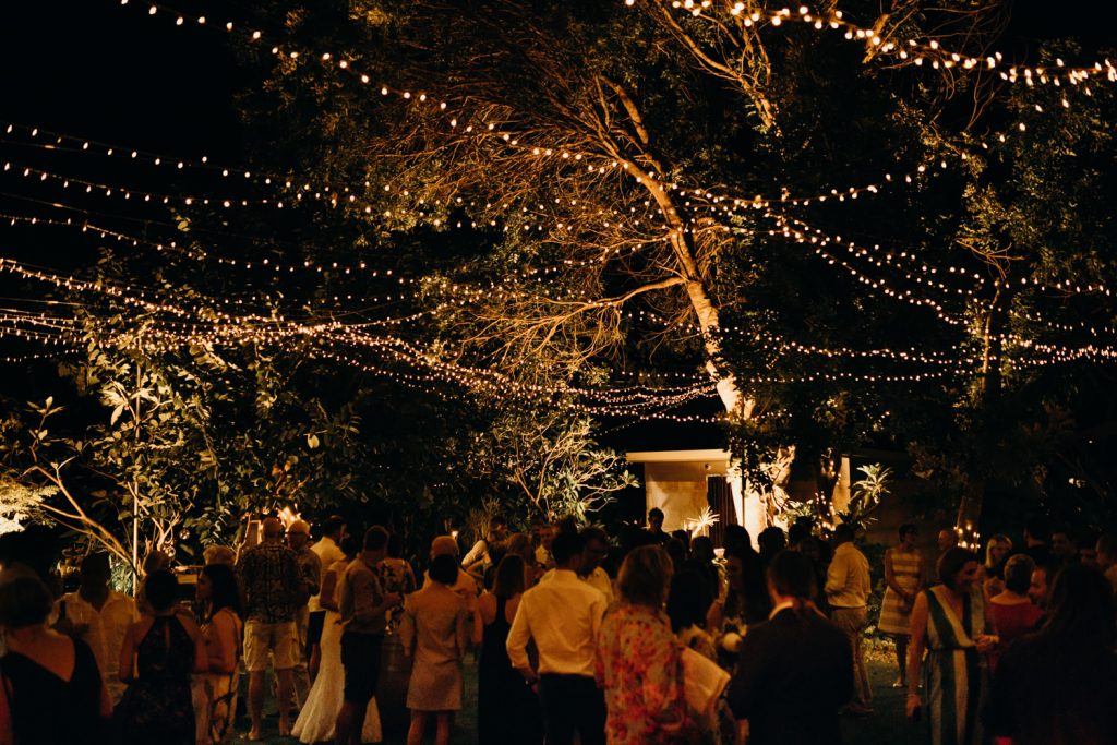 wedding reception at the billi resort in broome with fairy lights strung between trees and guests on dancefloor