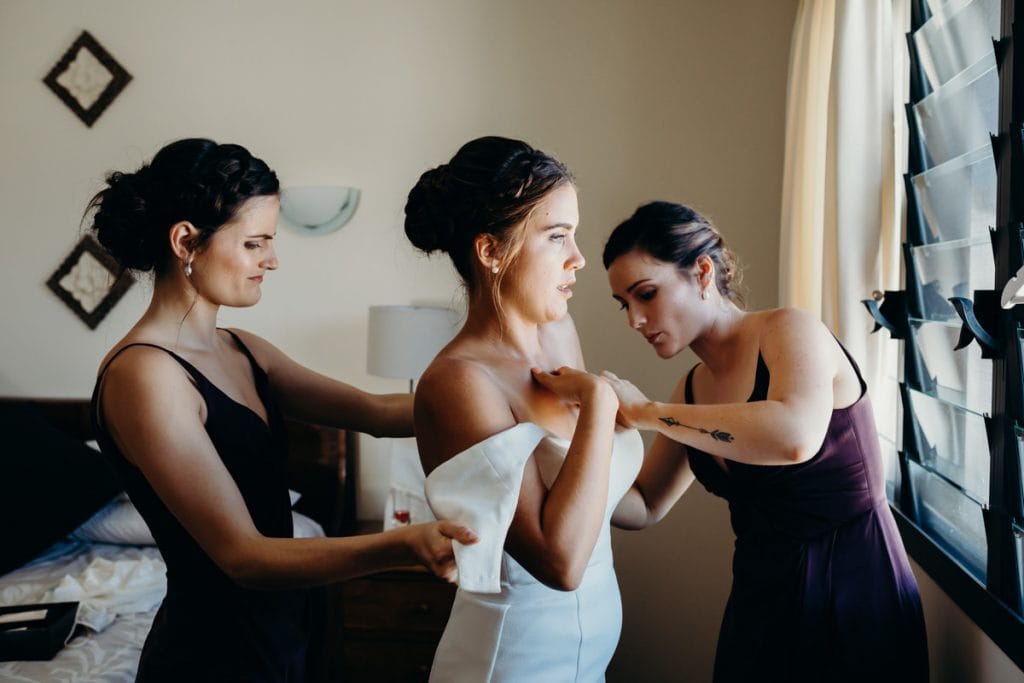 Broome bride is getting into her wedding dress with two girlfriends helping her