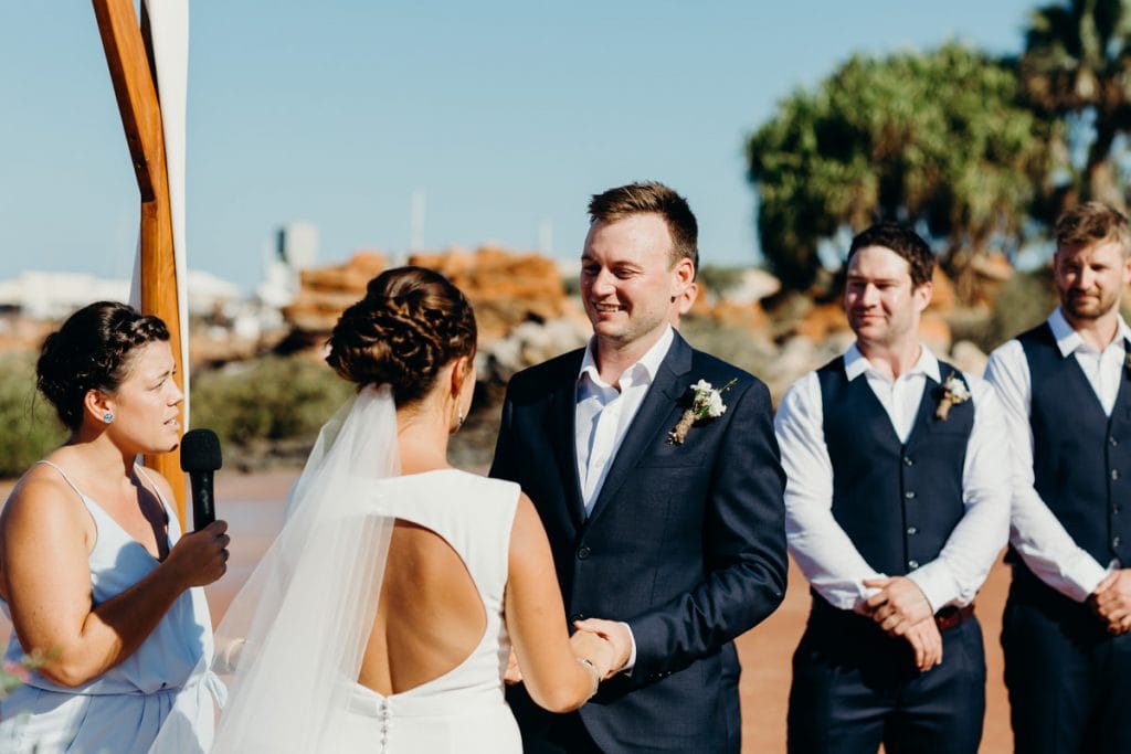 groom holds hands of bride and says his vows