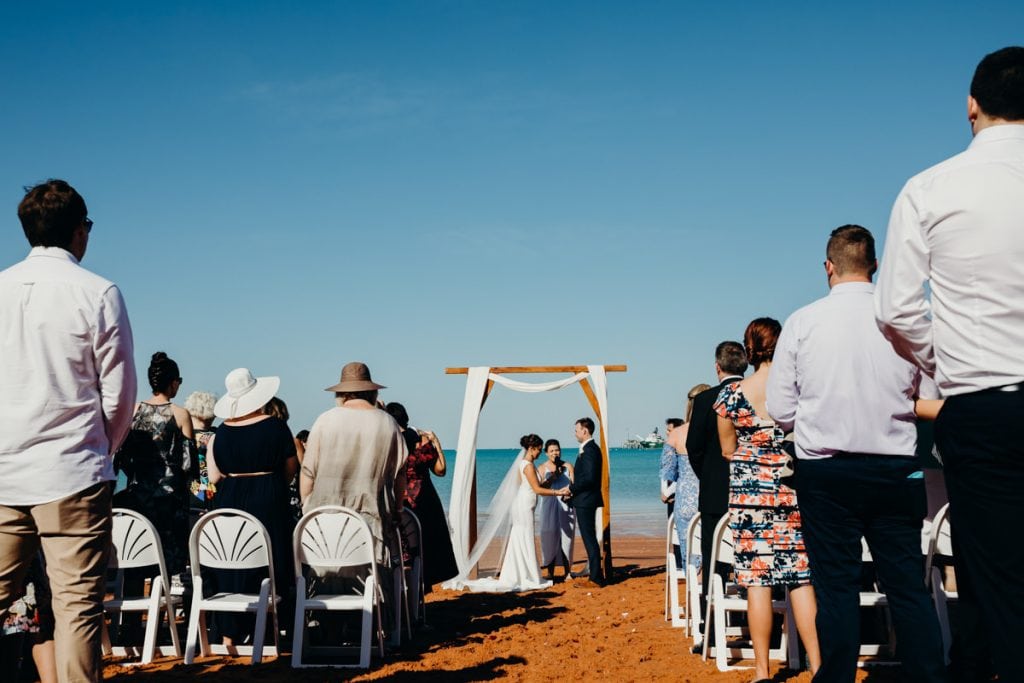 wedding guests are standing during beach ceremony at Broome Hovercraft base