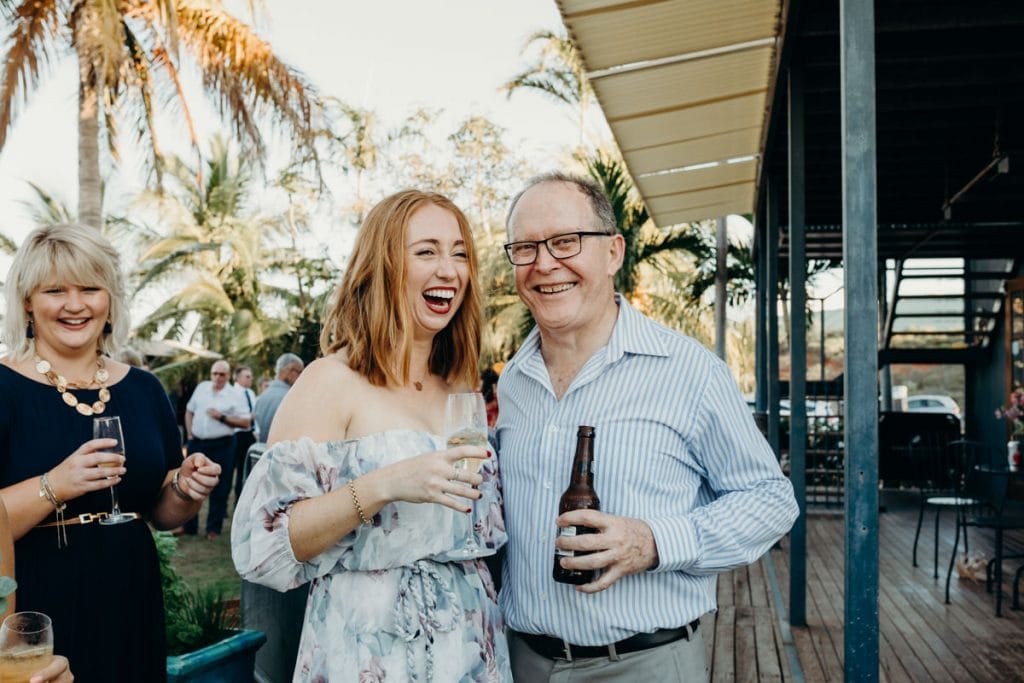 man and woman laughing with drinks in their hands