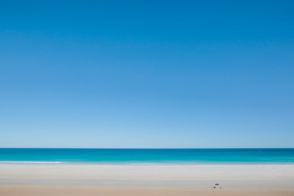 Cable Beach in Broome with one sun umbrella in the far distance