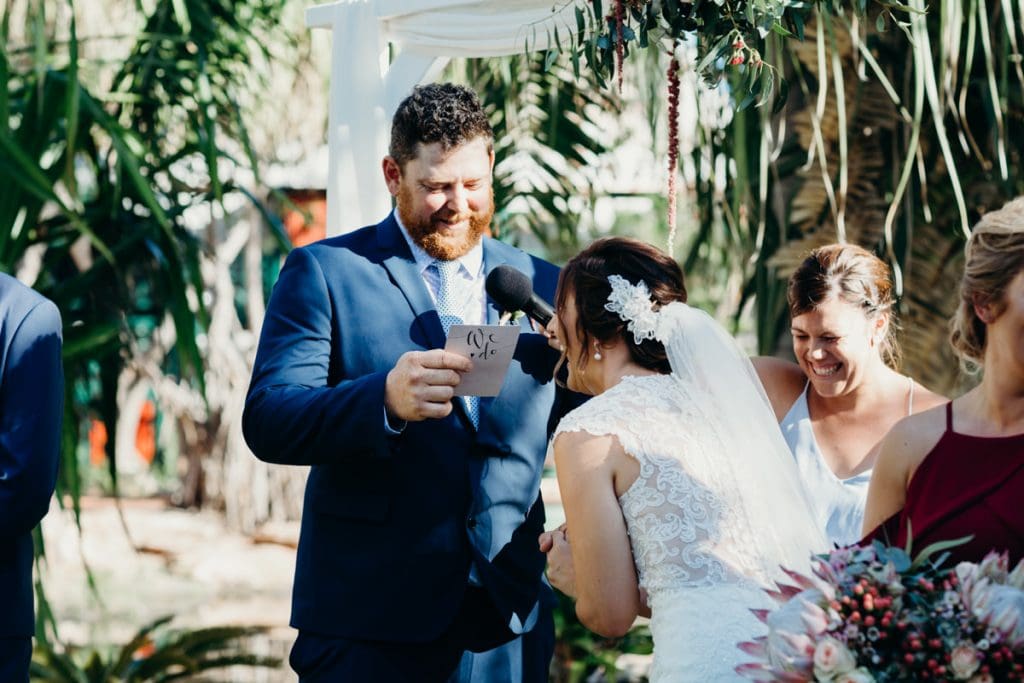 groom read his vows to bride who is laughing