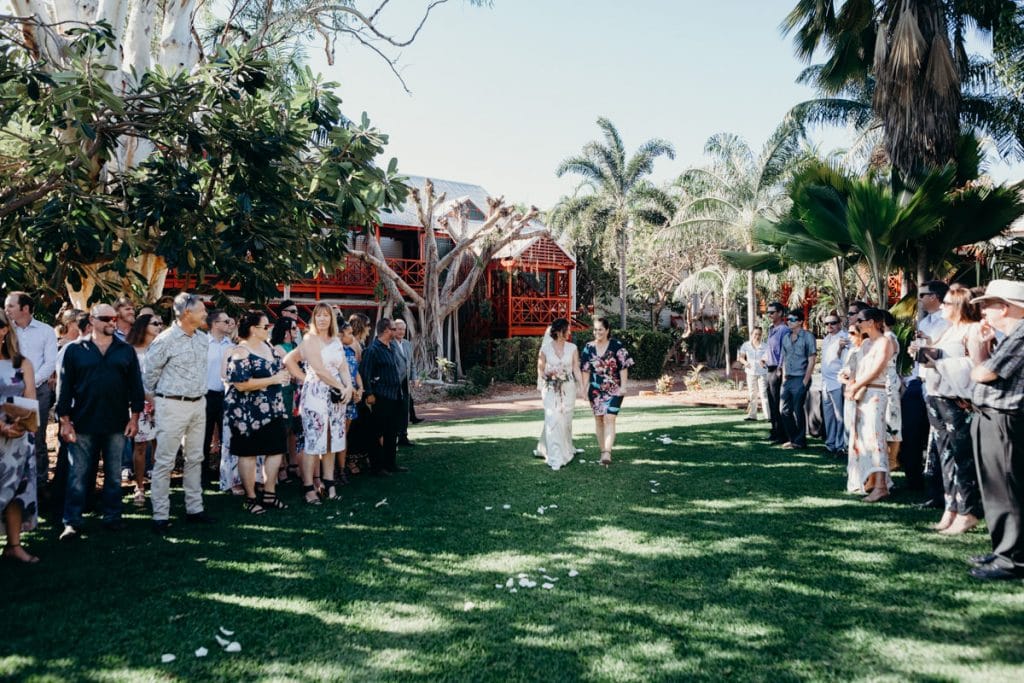 bride walks down the aisle at Lily Pond Lawn at Cable Beach Club Resort