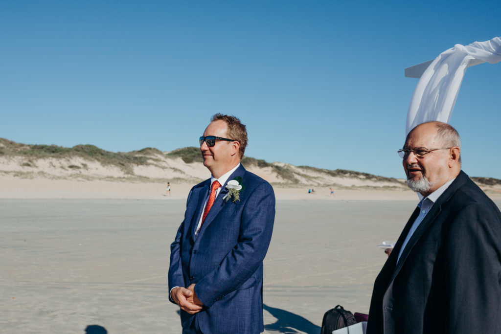 groom and wedding celebrant are waiting for the bride on Cable Beach in Broome Western Australia