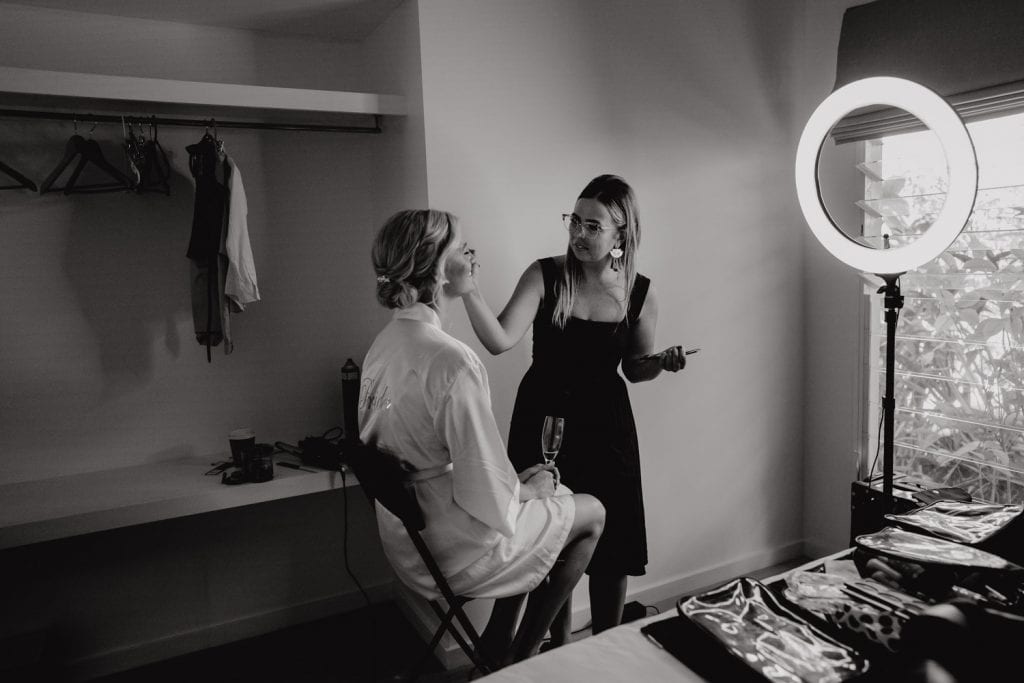 makeup artist getting the bride ready in hotel room in Broome