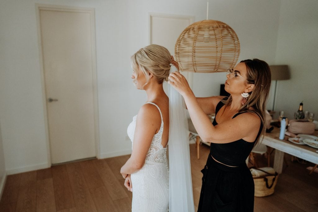 hair stylist attaches veil to bride's hair 