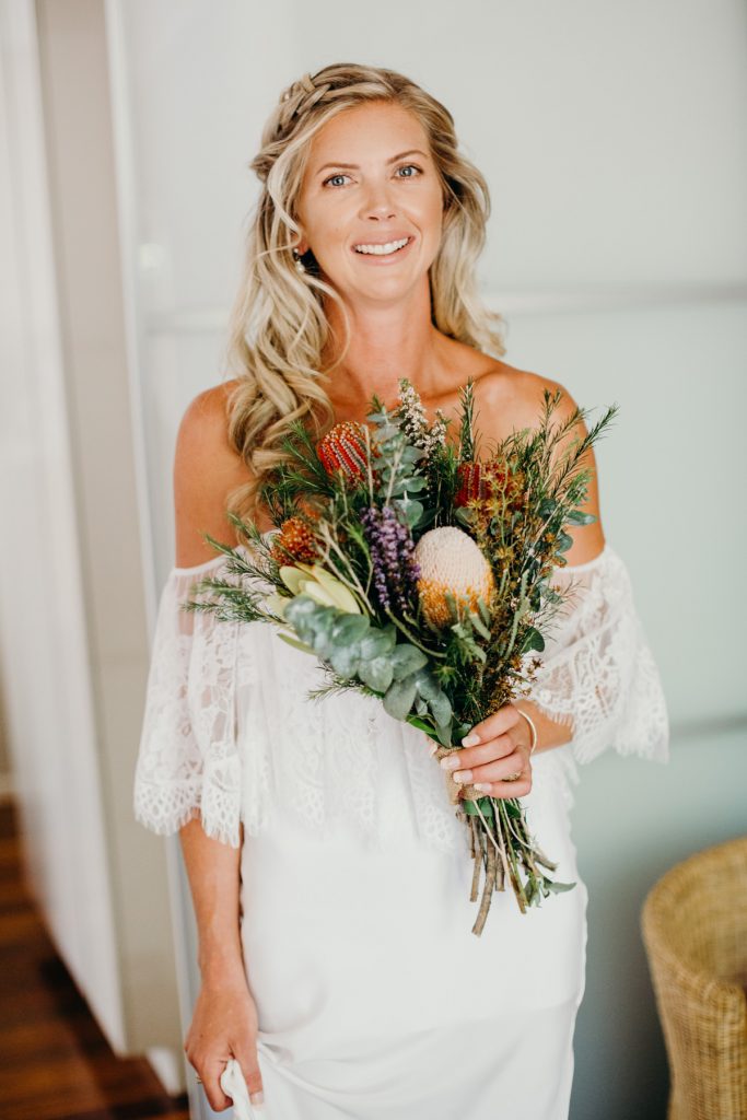 Portrait of bride in her wedding dress with wildflower bouquet in Broome hotel room 