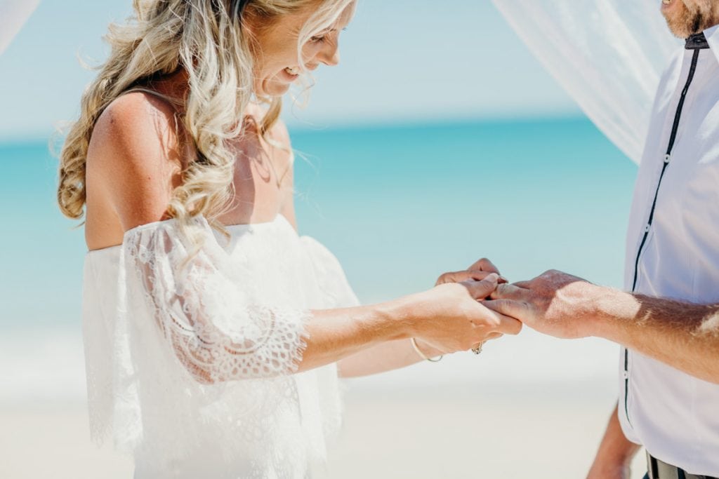 bride and groom exchange rings on Cable Beach