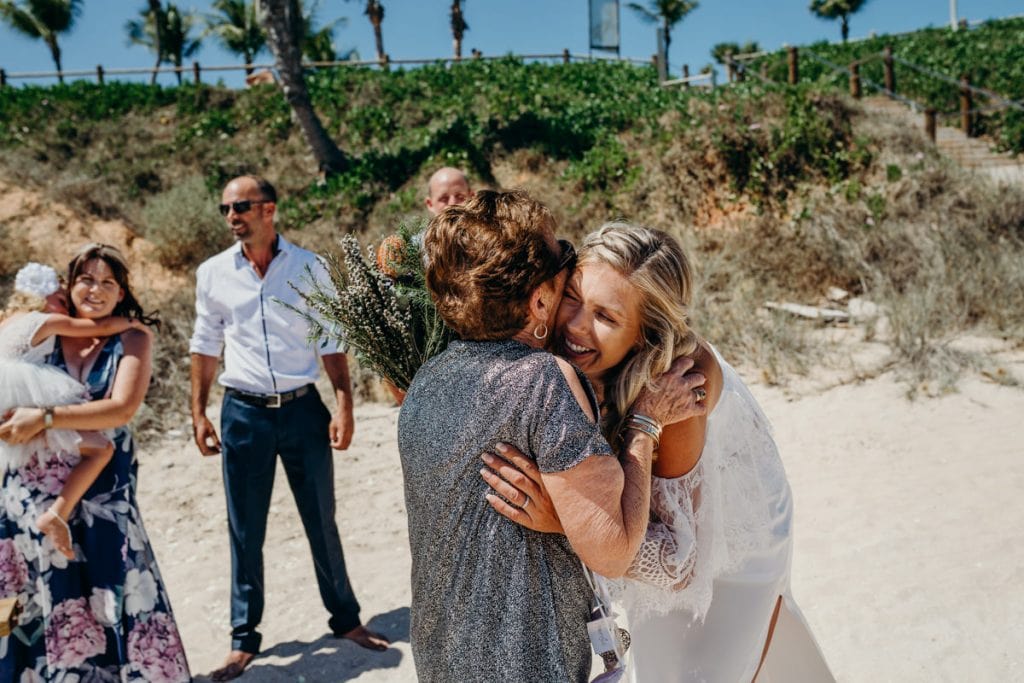 grandmother congratulates bride after beach ceremony