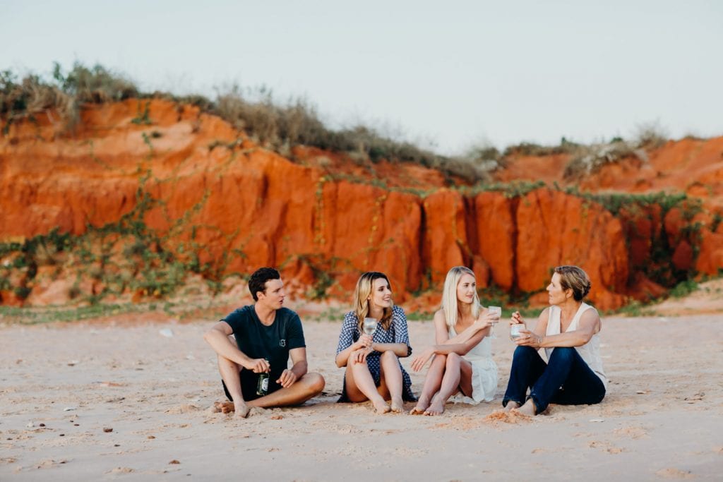 wedding guests drinking champagne and watching sunset on the beach in Broome