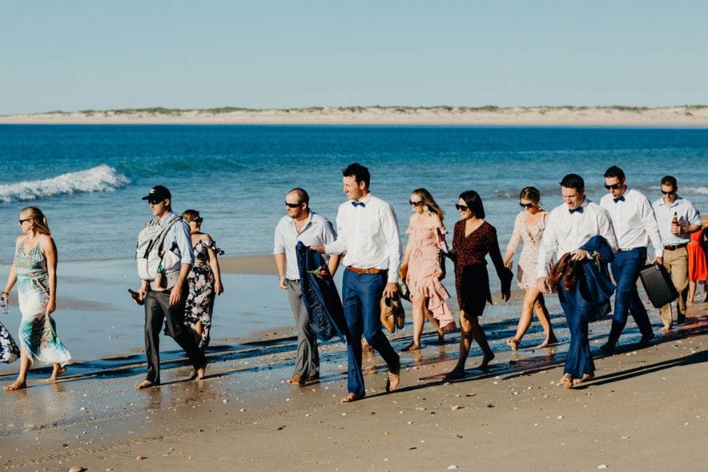 groom and wedding guests walking on Eco Beach
