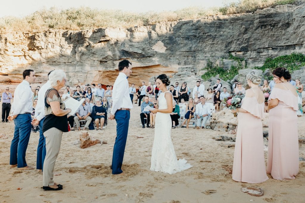 wedding ceremony on the beach with cliffs in the background