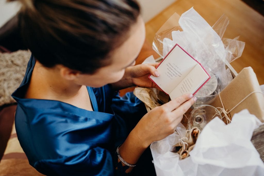 bride in blue robe with gift of her sister on her wedding day