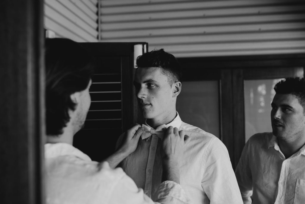 groomsmen fixing bow tie for groom at Cable Beach wedding