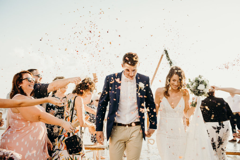 bride and groom walking through a confetti shower aisle at Cable Beach wedding