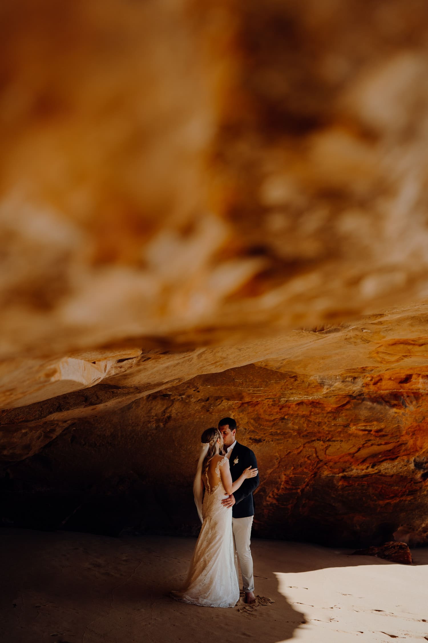 wedding couple shares a kiss in cave at their elopement at Eco Beach 