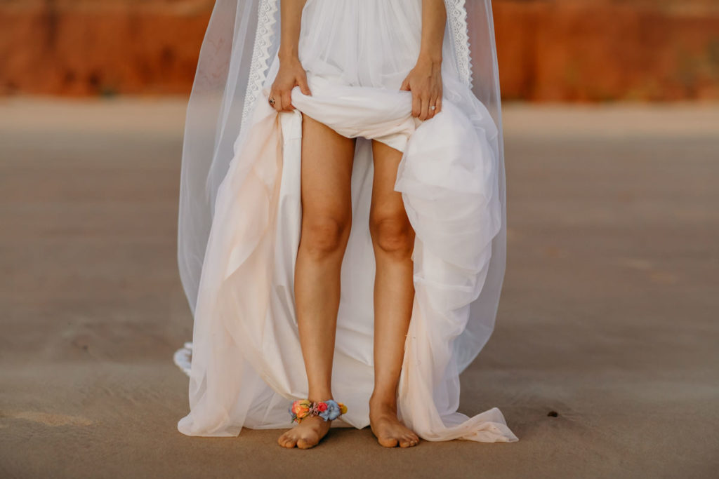 bride holding up her Zolotas Australia dress showing her flower anklet