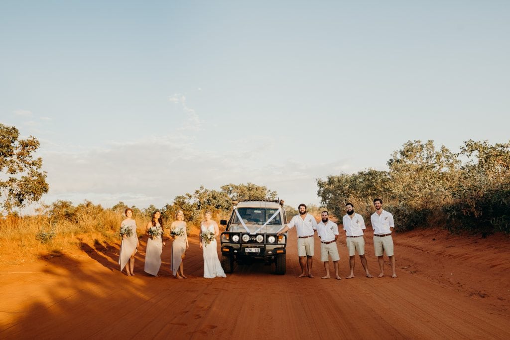Bridal party standing across the road with Troop Carrier in the middle
