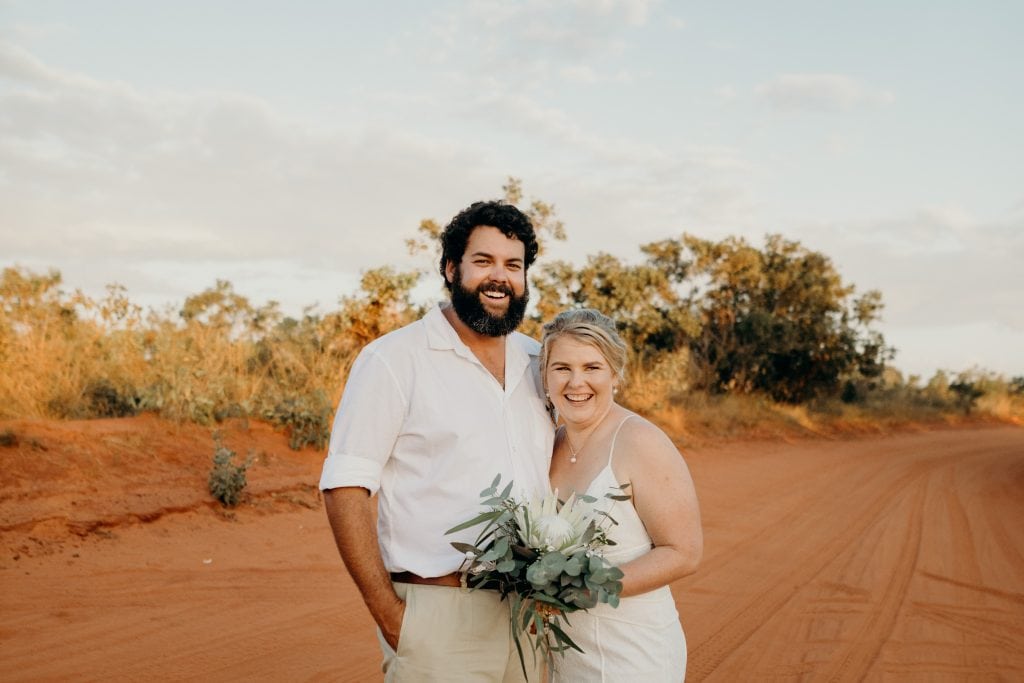 young wedding couple standing on red dirt road in the Kimberley Broome wedding