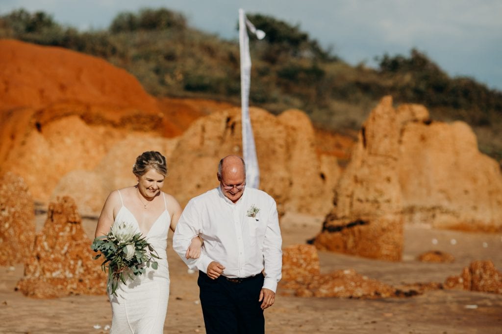 Father walks his daughter to the beach ceremony at Broome beach wedding