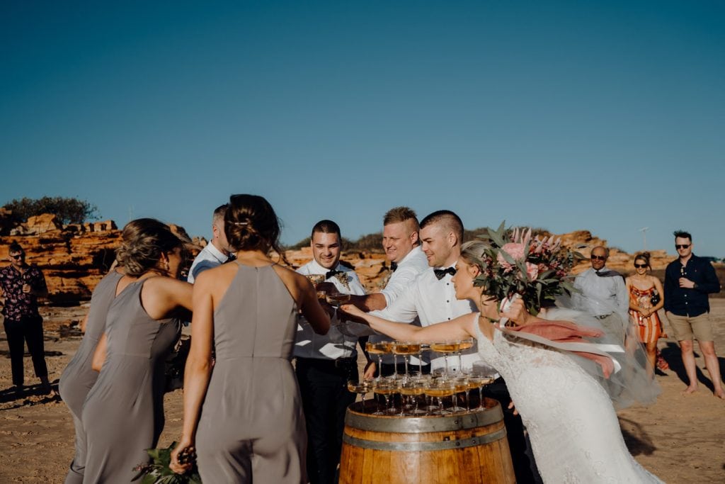 bridal party cheers with champagne to celebrant the wedding