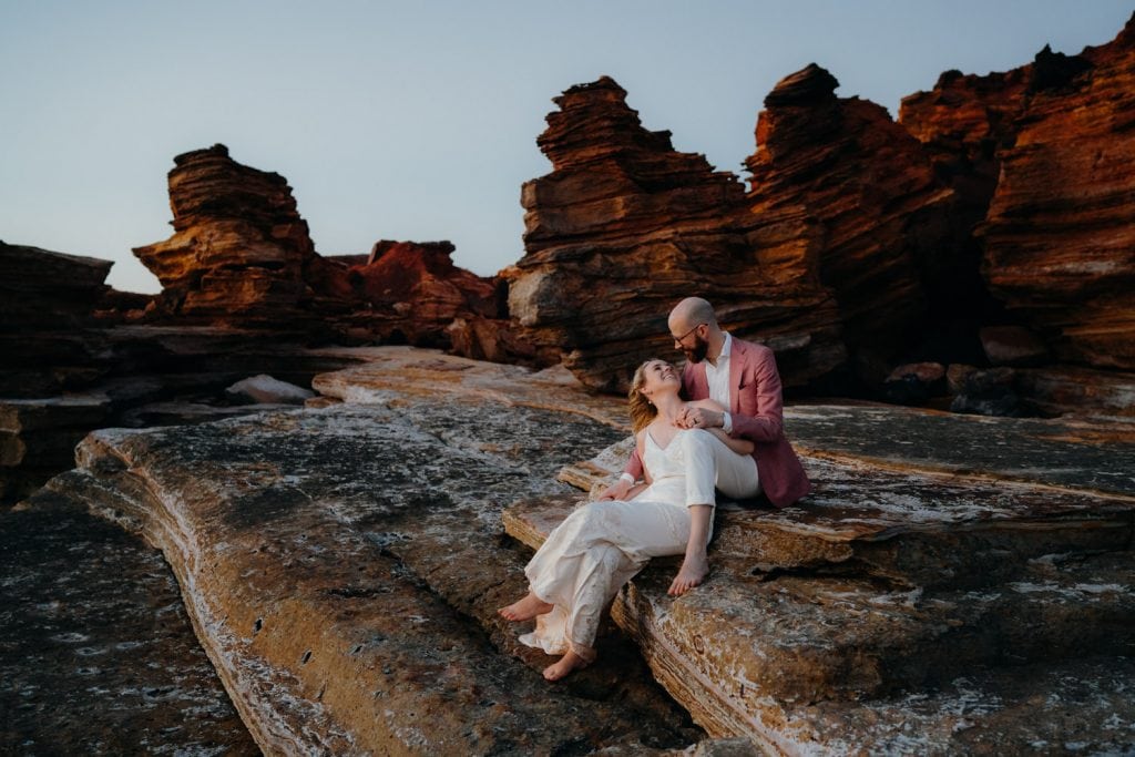 Broome elopement couple sits on big flat rock at Gantheaume Point in Broome