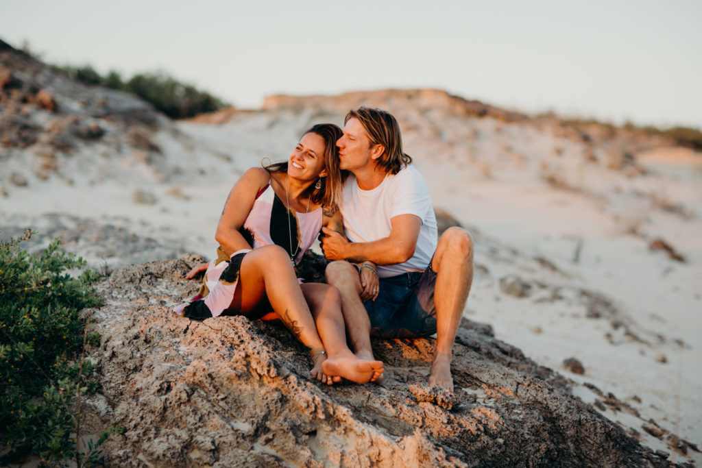 young couple watching the sunset on the beach in Broome